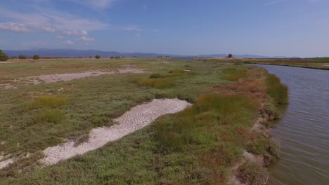 Antena:-Un-Delta-De-Un-Río-Con-Un-Puente-De-Carretera-Que-Lo-Atraviesa-Y-Algunos-Edificios-Agrícolas