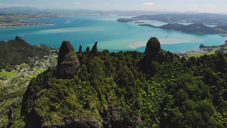 Rock-formation-on-Mount-Manaia-peak-aerial-orbit,-reveal-of-huge-bay-to-Whangarei-Harbour