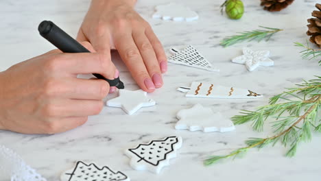 female hands decorate ornaments with star shape using a marker pen