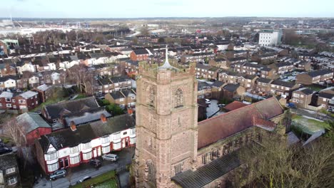 aerial slow right orbit view industrial small town frosty church rooftops neighbourhood north west england