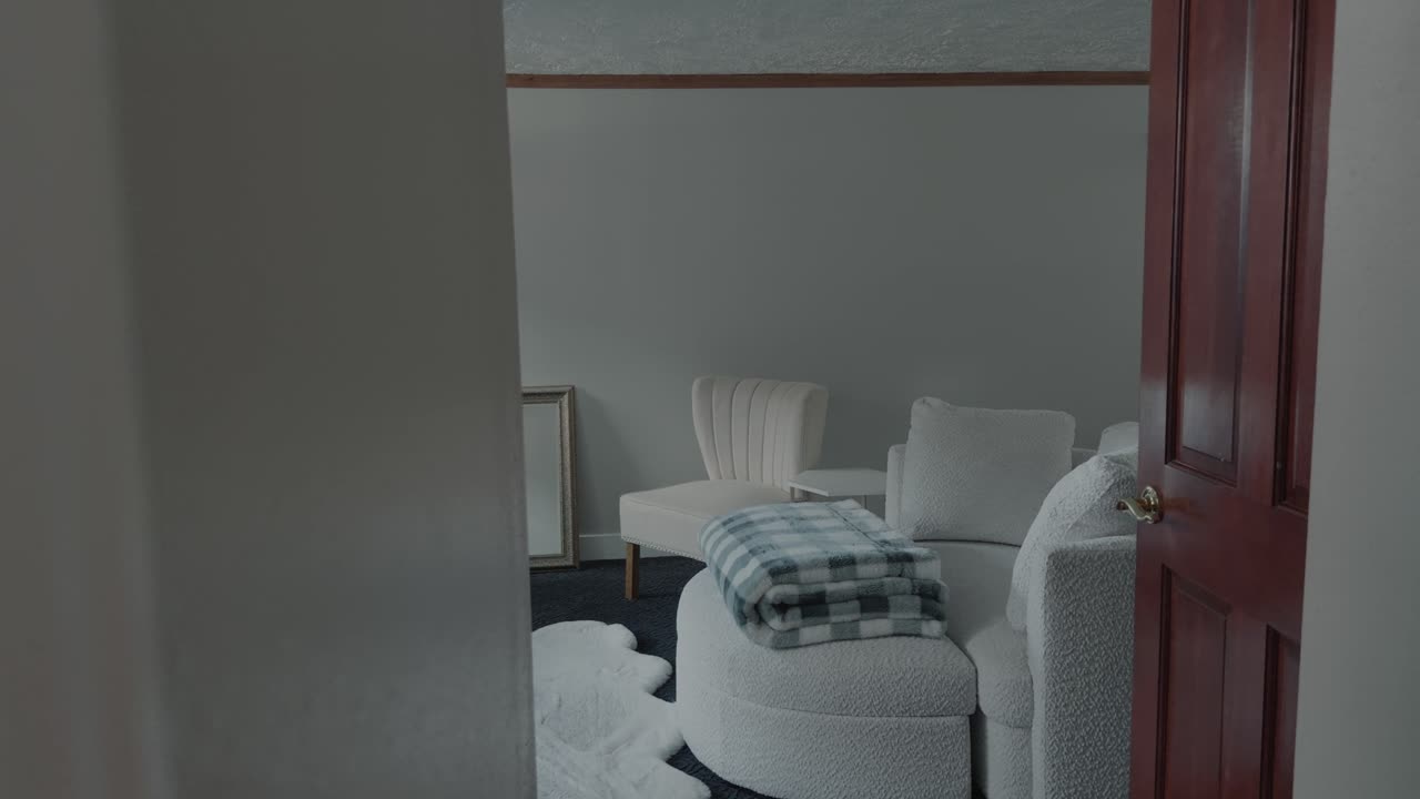 Smooth handheld glide reveals minimal living room interior with soft natural light