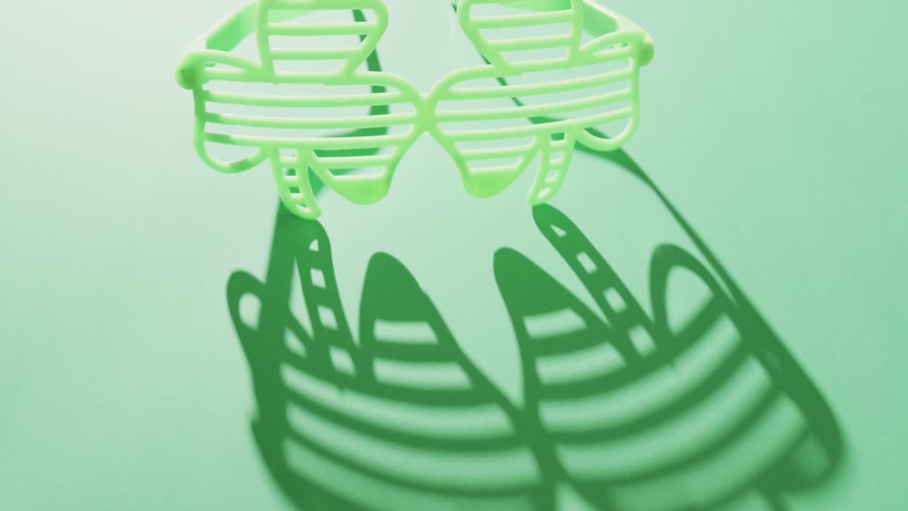 Video of st patrick's green shamrock glasses with copy space on green background