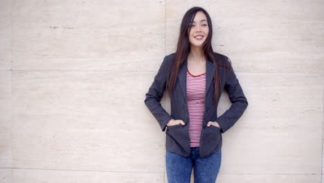 Trendy-young-woman-posing-against-a-wall