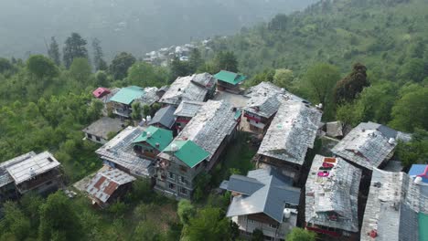 aerial view short of jibhi himachal pradesh in india. houses and trees in the mountainous area. faguli festival is one of the biggest festival in jibhi. the traditional houses here have stone roofs.
