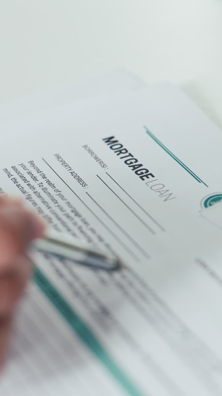 Primo piano di una mano con penna che esamina un documento di mutuo