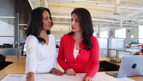 three architects discuss design plans in an office, close up