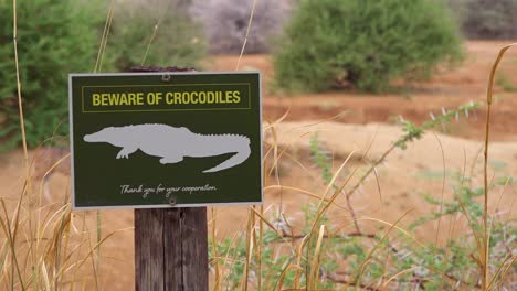 a sign warns tourists to beware of crocodiles