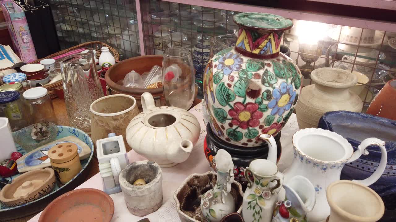 Close up shot at vintage tea pottery, plates and glasses at flea market store