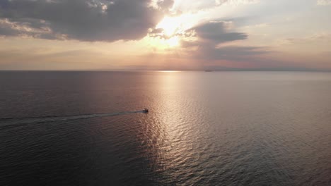 drone video mar tranquilo hora de oro barco de pesca pasando el atardecer grecia verano