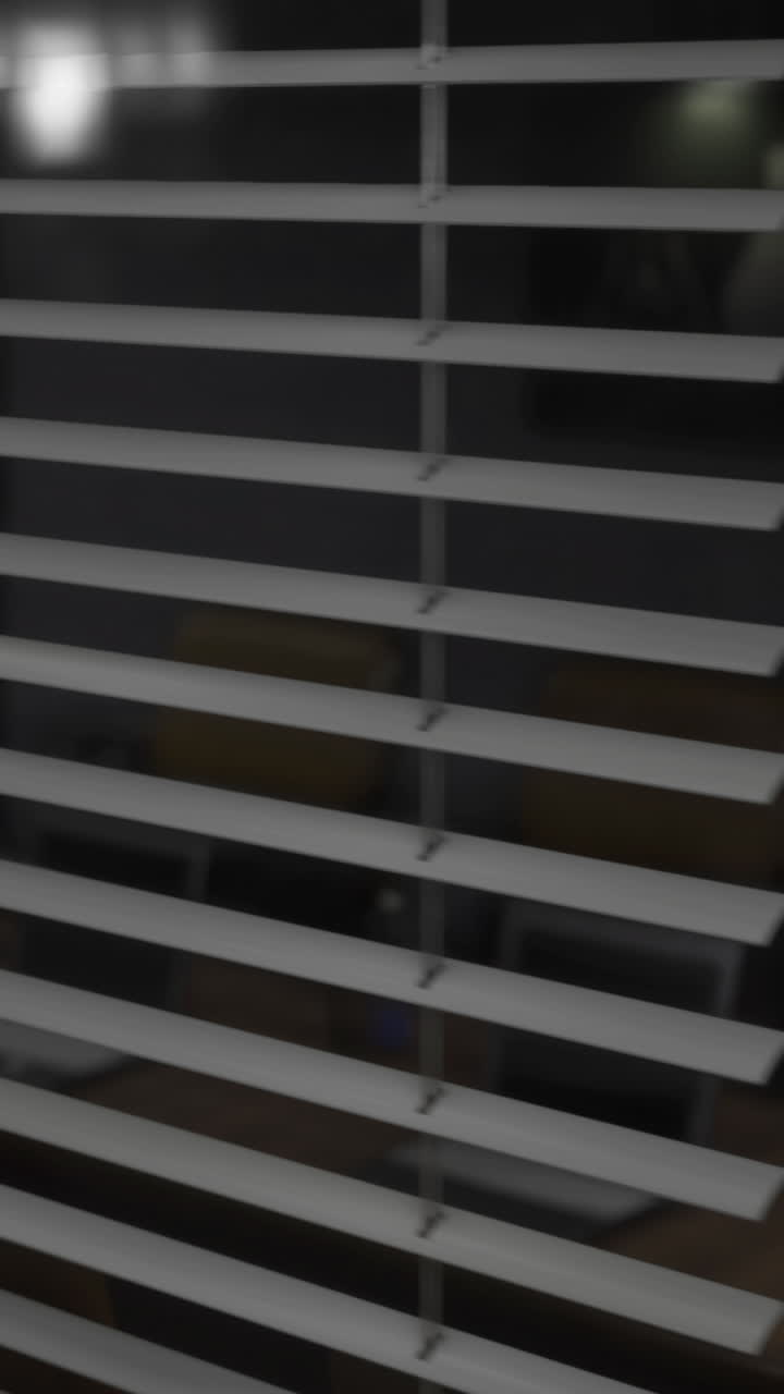 Looking through blinds at a quiet modern space in the evening light