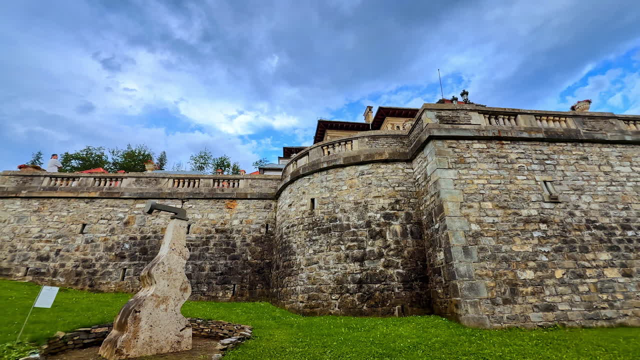 Busteni, Romania, 17 July 2025: Stone wall of the terrace in front of Cantacuzino Castle in Busteni, Romania. Walking by the territory of the famous landmark on cloudy day