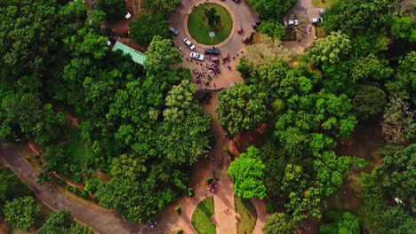 Top-down-aerial-of-people-and-traffic-in-a-beautiful-green-park-in-Abuja,-Nigeria