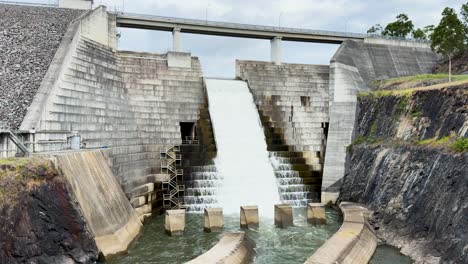 el agua fluye por el vertedero de la presa hacia el río