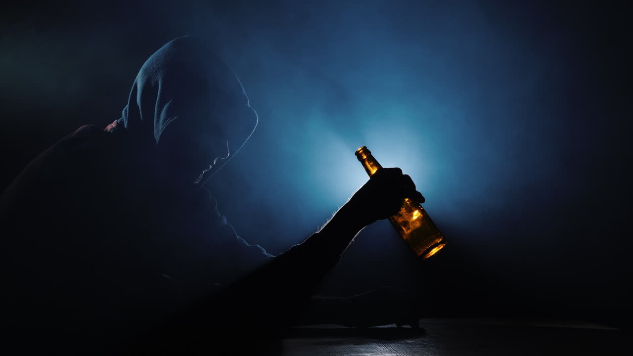 손에 빈 병을 들고 있는 알코올 중독자의 실루엣