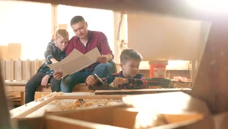 familia, carpintería, madera y concepto de la gente. el padre enseña a su hijo carpentería.
