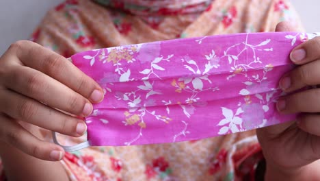 woman holding a pink floral face mask