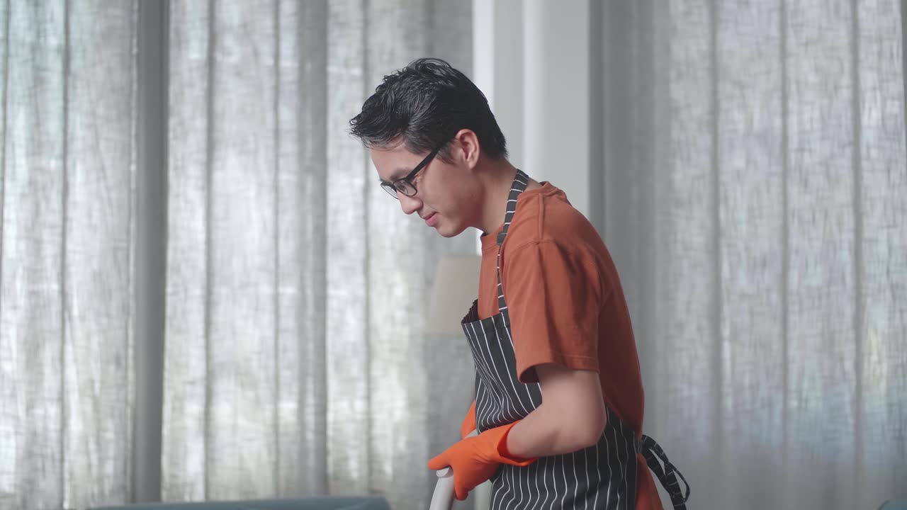 アジアの男性家政婦が前をかぶって家で床を掃除するのを楽しんでいます