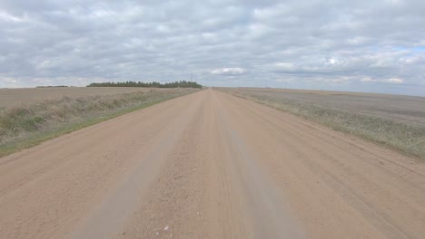 Heckfensteransicht-Während-Der-Fahrt-Auf-Einer-Geraden-Schotterstraße-Durch-Das-Ländliche-Nebraska-An-Einem-Bewölkten-Wintertag