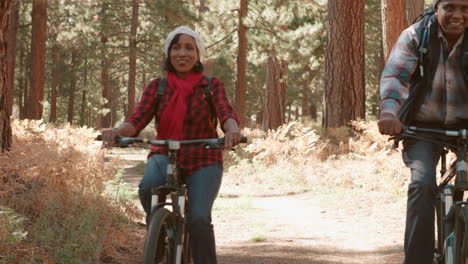 Una-Pareja-De-Ancianos-Negros-Pasa-En-Bicicleta-Por-La-Cámara-En-Un-Sendero-Forestal