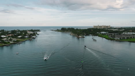 drone shot of the jupiter inlet with boats passing in jupiter, florida