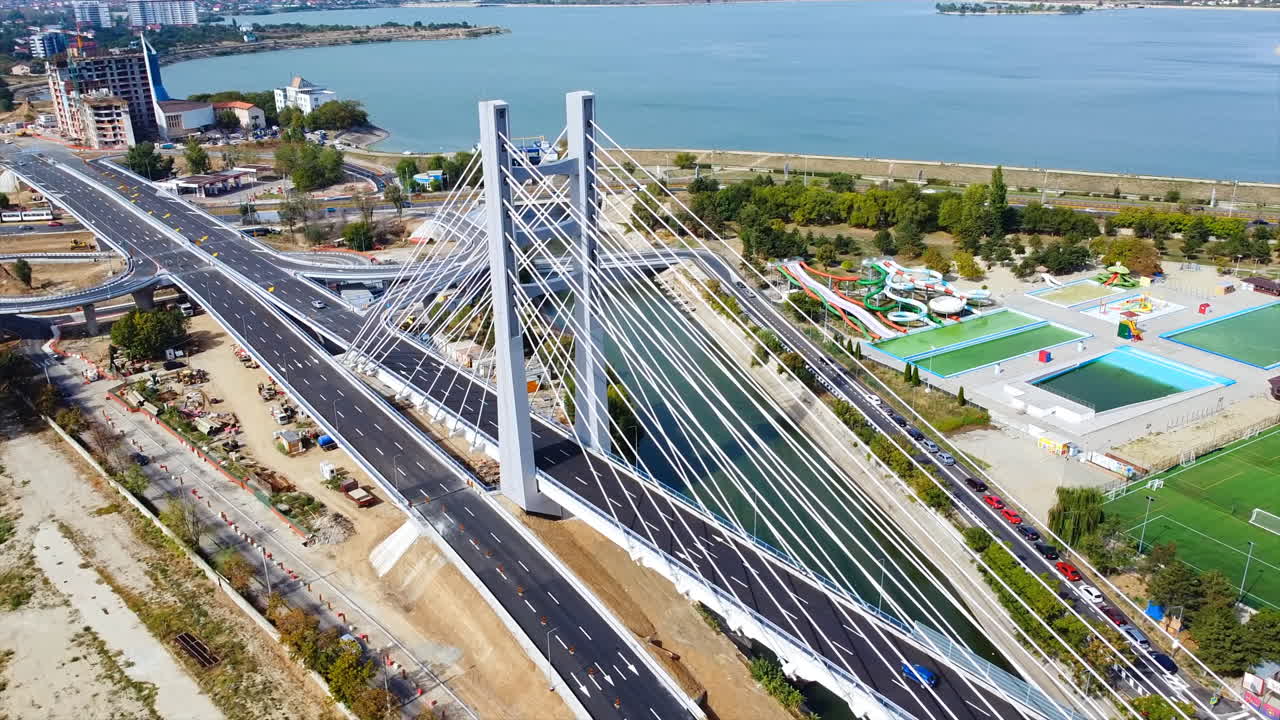 Ciurel passage, bridge over a river with moving cars, recreational complex, lake. View from the drone. Bucharest, Romania