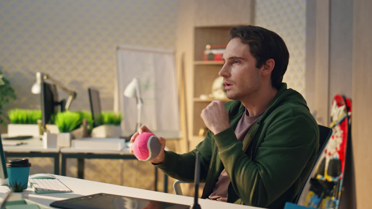 el principiante pensativo lanza la pelota pensando de cerca en la habitación. el hombre crea ideas