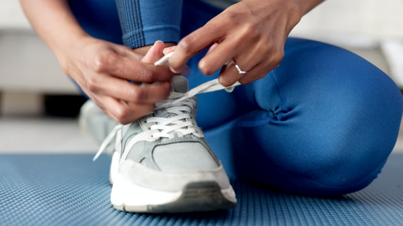 Mãos de mulher amarrando os sapatos para se exercitar