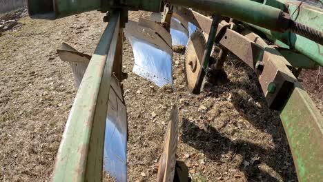 close up on disc and chisel of plow as farmer moves plow to the field