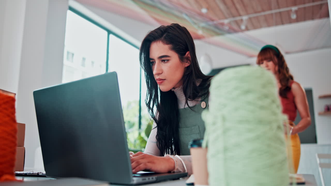 mujer trabajando en una computadora portátil en una oficina creativa