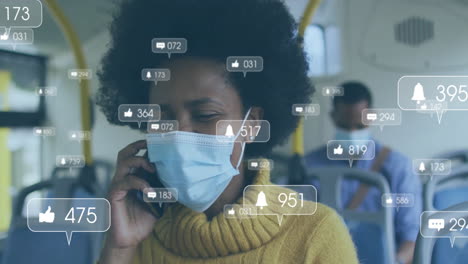 Animation-of-media-notifications-over-african-american-woman-in-mask-talking-on-phone-on-bus