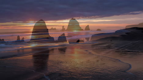 dramatic sunset over sea stacks on a coastal beach
