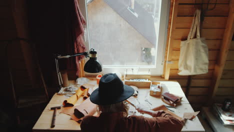 man working at desk in leathercraft workshop