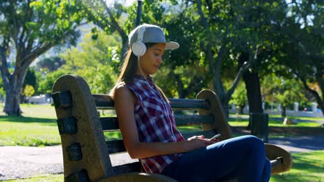 Woman-listening-music-in-park-4k