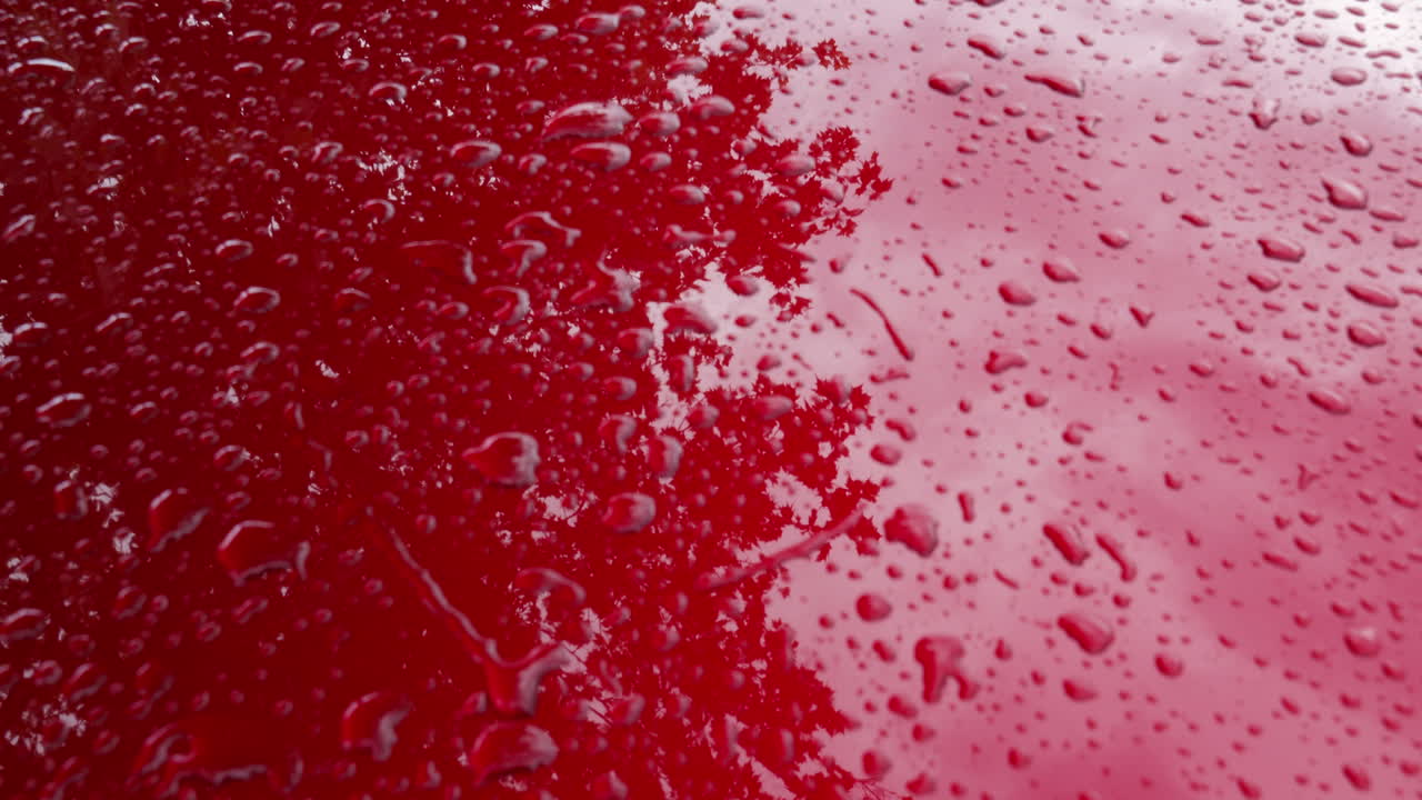 비가 내린 후 자동차 후드에 손으로 심장을 그리는