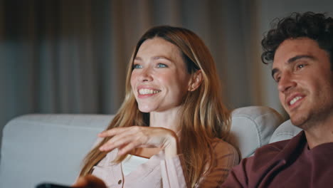 overjoyed family watching tv sitting at cozy living room late evening closeup