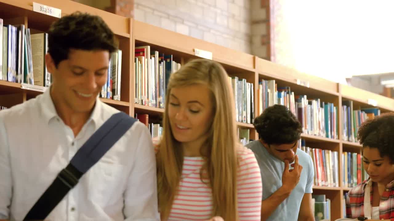 Standing classmates studying in library
