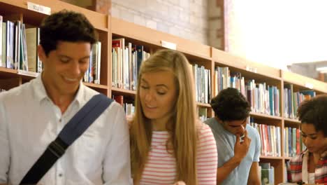 compañeros de clase de pie estudiando en la biblioteca