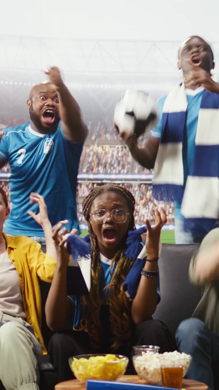Video vertical: Aficionados al fútbol emocionados por un gol, sintiéndose transportados a las tribunas del estadio.