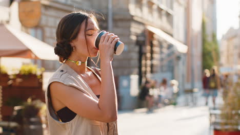 young woman girl enjoying drinking morning coffee hot drink, relaxing, taking a break in city street