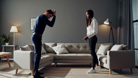 una pareja discutiendo en la sala de estar.