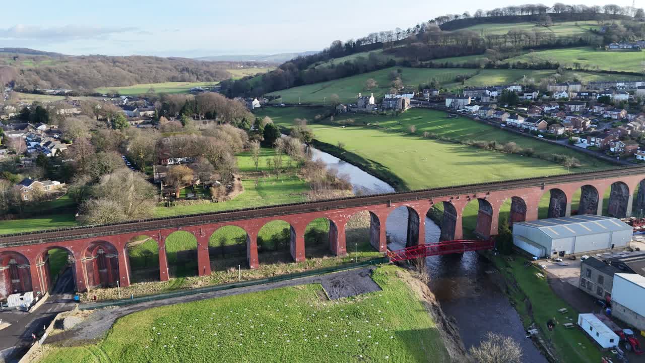 Drone footage of Heidelberg's picturesque landscape with the historic Old Bridge, vibrant greenery, and serene river. Capturing the tranquil mood under soft daylight with no people visible