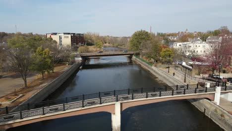 aerial view of a bridge and river, trees on the sides with forest in the background