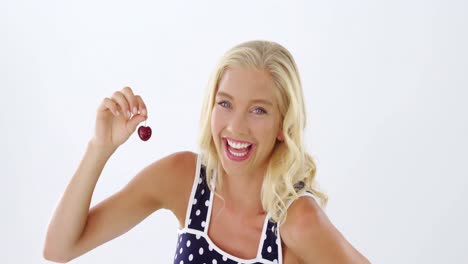 Beautiful-woman-holding-cherry-against-white-background