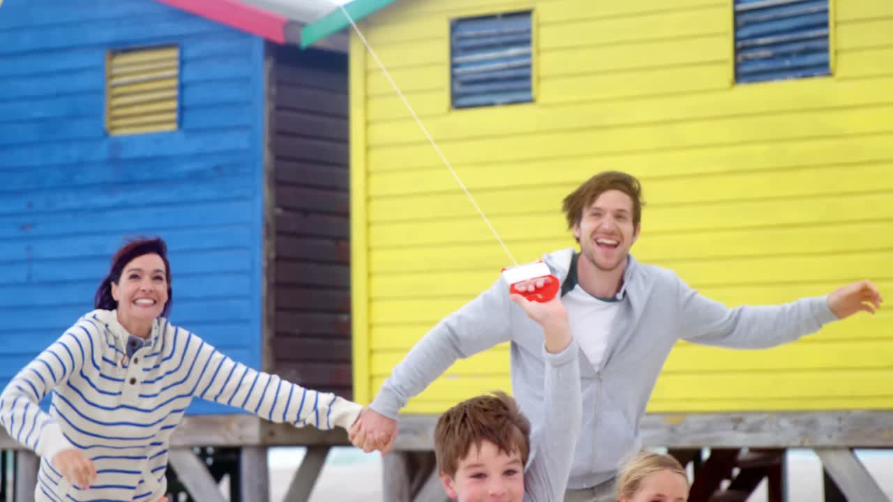 Family flying kite at beach