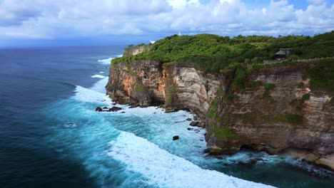 waves crashing on the karang boma cliff - uluwatu cliff in bali, indonesia