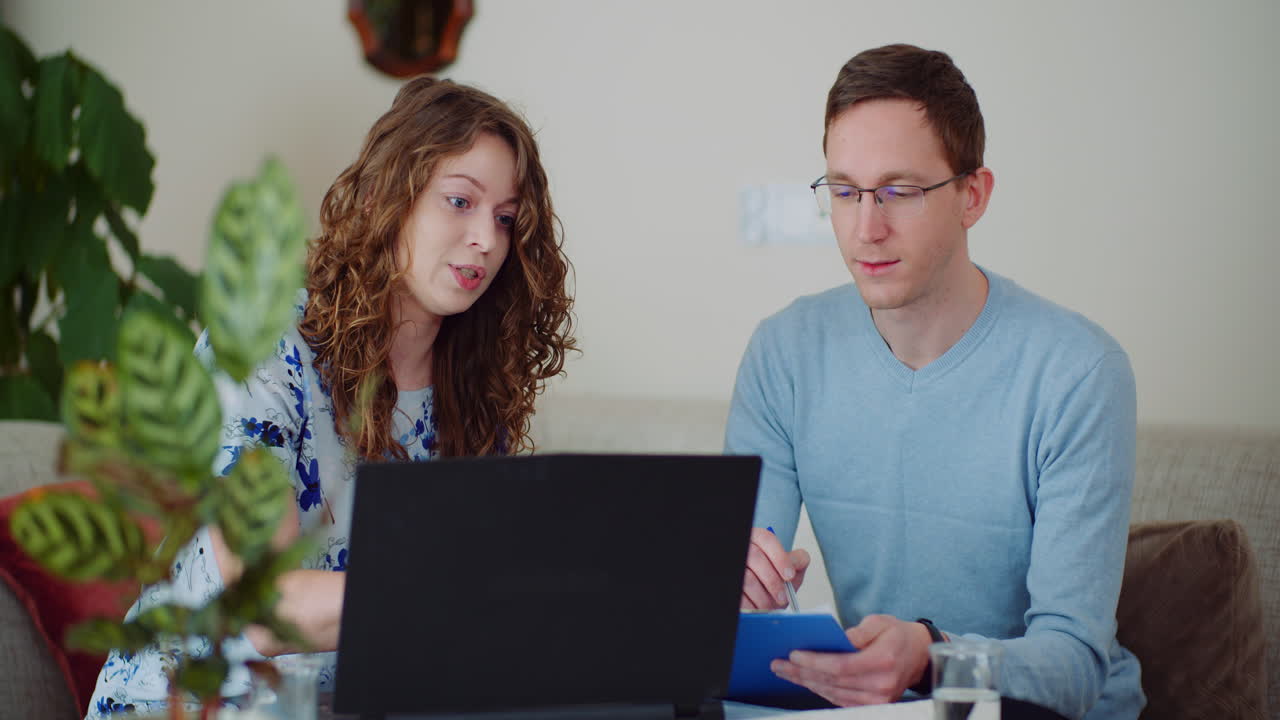 Uomo d'affari e donna d'affari che parlano di un progetto mentre lavorano al computer portatile nell'ufficio di casa