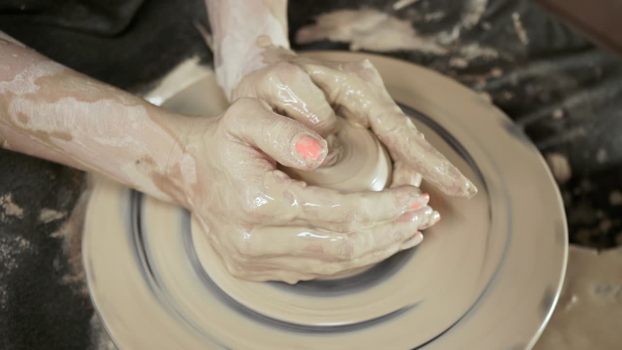 una mujer alfarera hace platos de arcilla. una mujer hace una jarra en la rueda de un alfarero