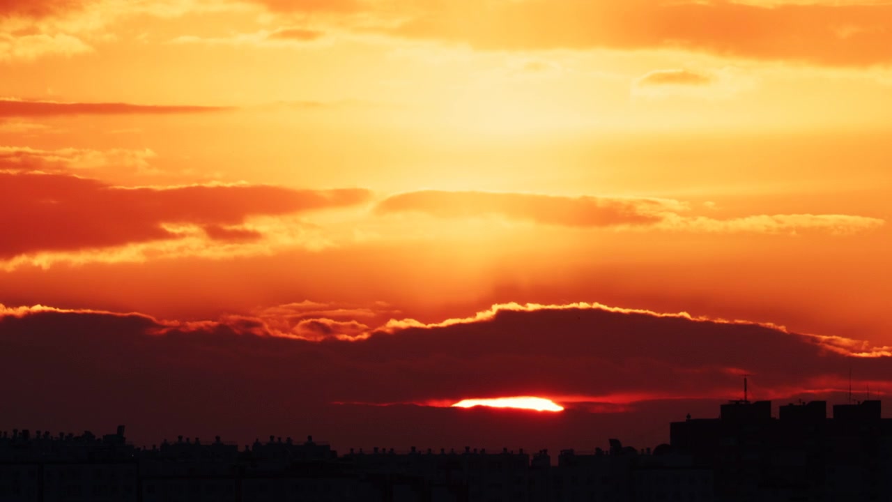 Heller goldener Sonnenuntergang, der eine moderne Stadt-Skyline beleuchtet
