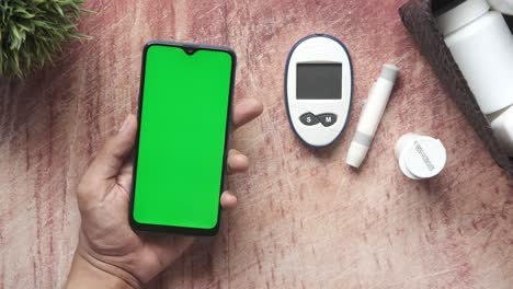 mujeres mayores mano usando teléfono inteligente en la mesa con herramientas de medición diabética