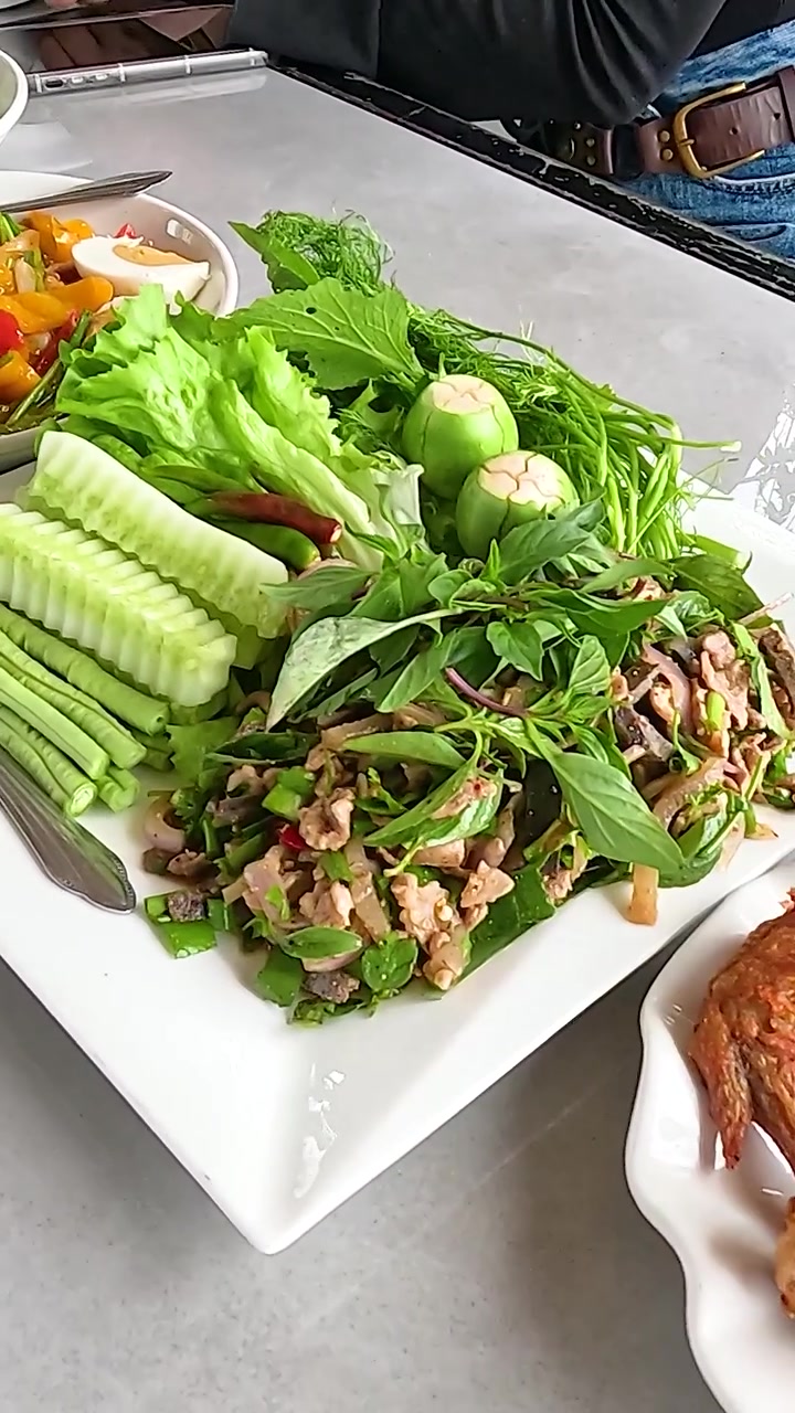 Một loạt các món ăn đầy màu sắc trên bàn trong không gian ăn uống sáng sủa, thoải mái. Được chụp tại Lào